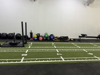 Rincón de material funcional de Serfit con trineo, balones medicinales, kettlebells y bandas de resistencia ordenados